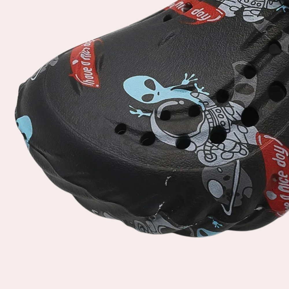 Zwarte klomp met alienprint en ventilatiegaten, ideaal voor casual gebruik. Comfortabele en trendy schoenen voor dagelijks gebruik.
