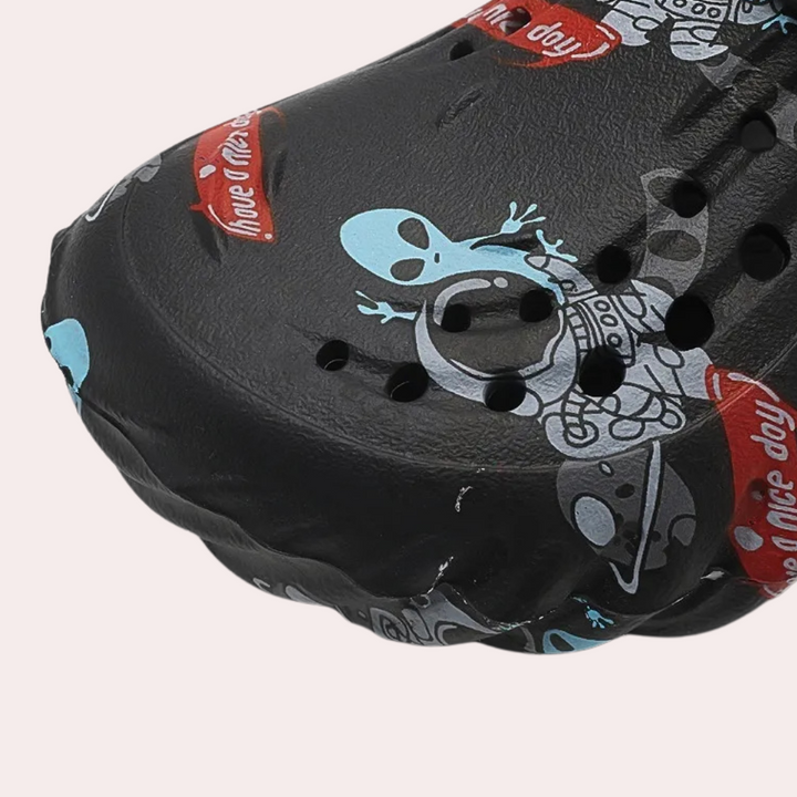 Zwarte klomp met alienprint en ventilatiegaten, ideaal voor casual gebruik. Comfortabele en trendy schoenen voor dagelijks gebruik.