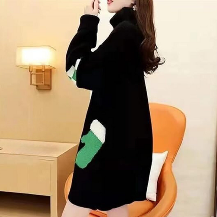 Vrouw in zwarte trui jurk met groene en witte accenten, zittend op oranje stoel in moderne kamer. Wintermode, stijlvolle dameskleding.