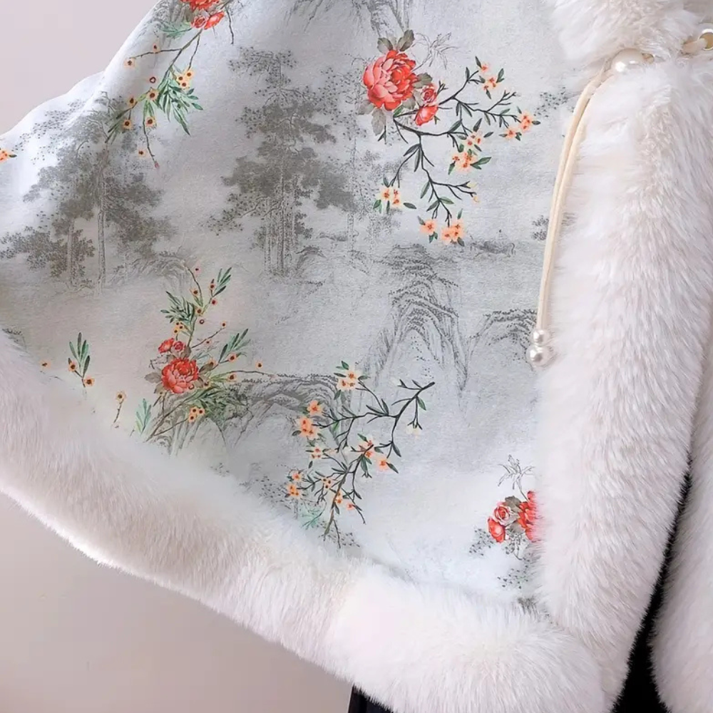 Witte bontcape met bloemenprint en parelsluiting, elegante wintermode, dameskleding, warme en stijlvolle cape, modieuze accessoire.