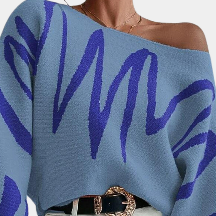 Blauwe trui met abstracte paarse zigzagprint, off-shoulder ontwerp, modieuze dameskleding, trendy herfst- en wintermode.