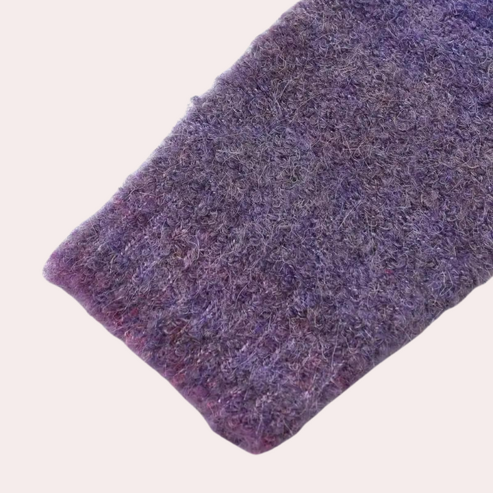 Paarse gebreide mouw van wollen trui, textuur detail. Zachte, warme stof, ideaal voor wintermode. Hoogwaardige kwaliteit, trendy design.