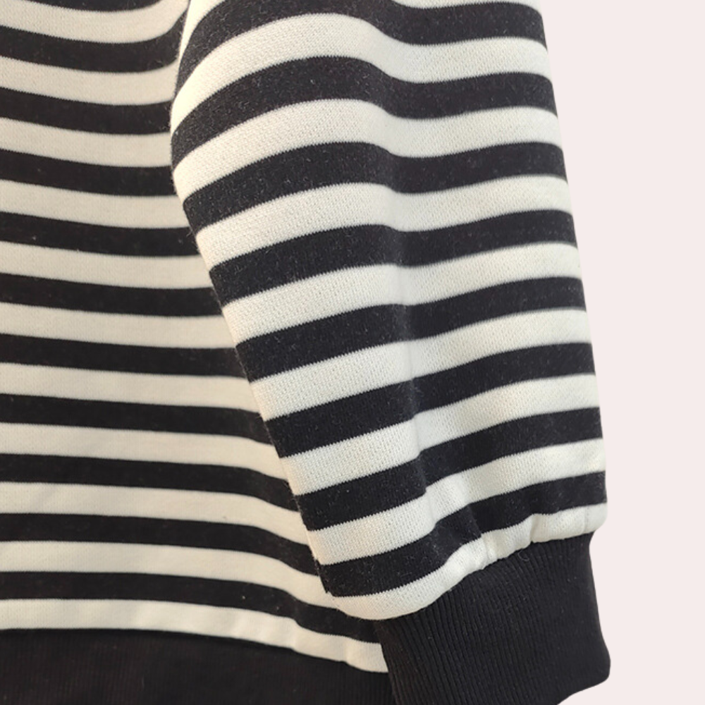 Gestreepte zwart-witte trui met lange mouwen, close-up. Modieuze kleding, casual stijl, comfortabele stof. Perfect voor herfst- en winterseizoen.