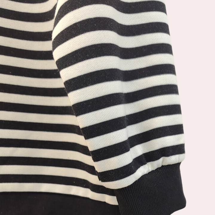 Gestreepte zwart-witte trui met lange mouwen, close-up. Modieuze kleding, casual stijl, comfortabele stof. Perfect voor herfst- en winterseizoen.