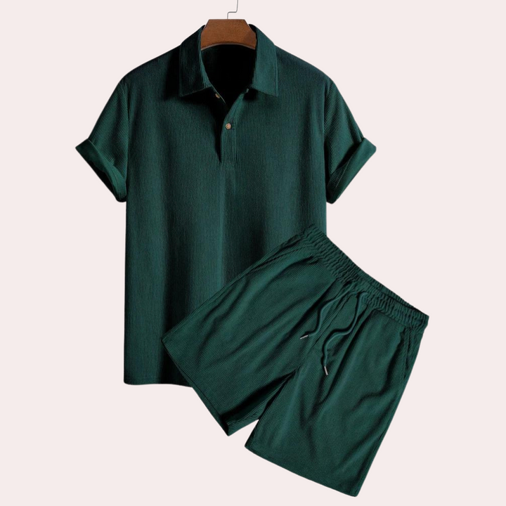 Donkergroen corduroy zomerset voor heren, bestaande uit een poloshirt en korte broek. Stijlvolle herenkleding, perfect voor casual zomeroutfits.
