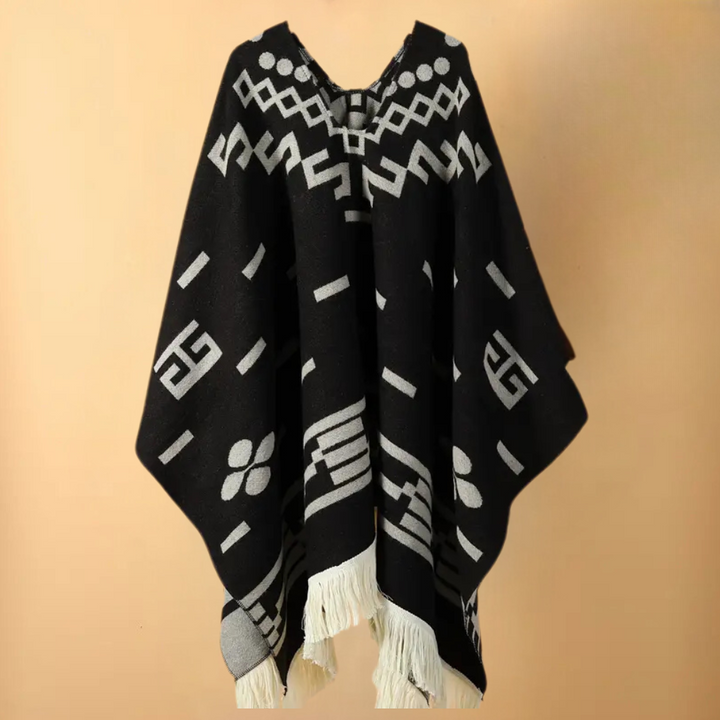 Zwart-witte poncho met geometrische patronen en franjes, etnisch design, warme wollen stof, unisex modeaccessoire, boho stijl.
