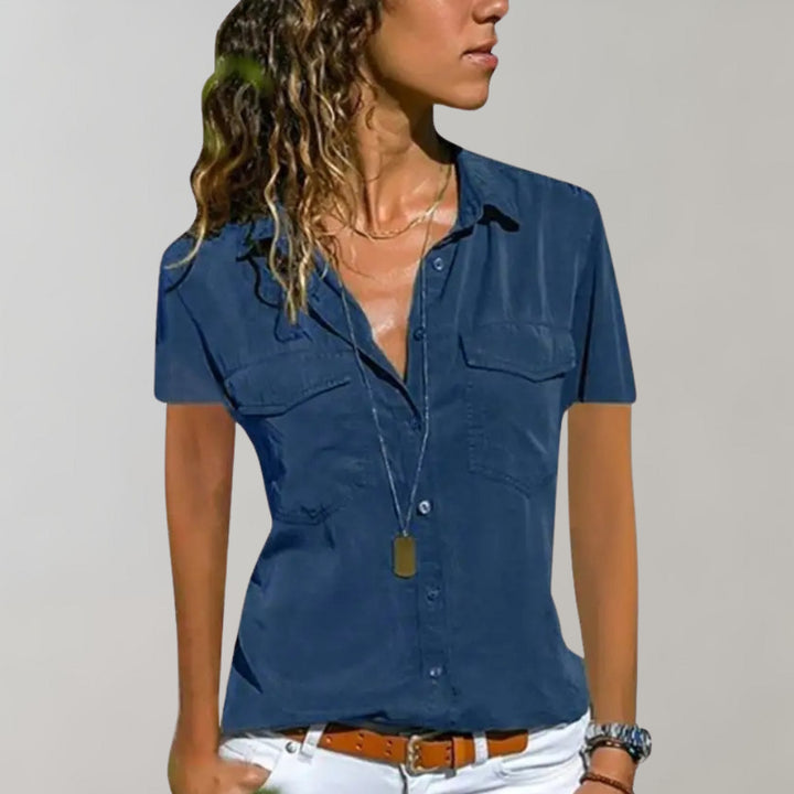 Blauwe damesblouse met korte mouwen, knoopsluiting en borstzakken. Perfect voor casual en zakelijke outfits. Modieuze dameskleding.