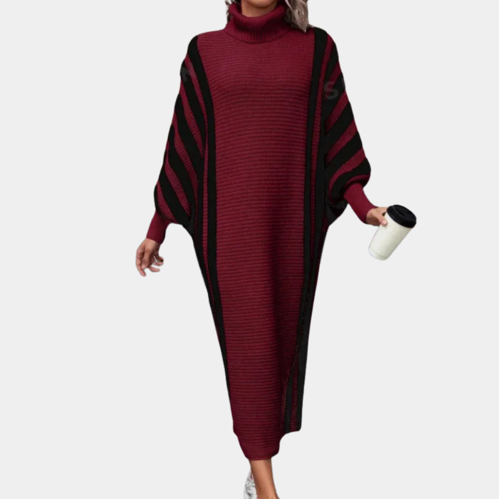 Vrouw in bordeauxrode, gestreepte trui-jurk met col, draagt een witte beker. Modieuze winterkleding, comfortabele damesmode.