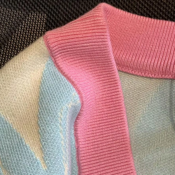 Roze en blauwe gebreide trui met geribbelde kraag, close-up. Modieuze dameskleding, zachte pasteltinten, comfortabele stof.