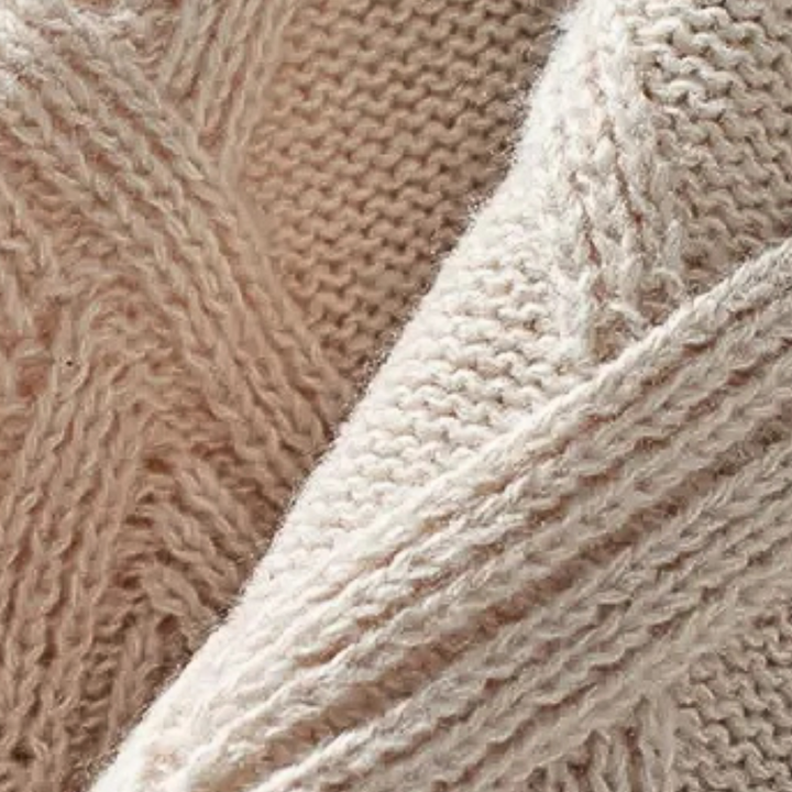 Beige gebreide wollen trui close-up, kabelpatroon, zachte textuur, wintermode, warme kleding, comfortabele stof, modetrend.