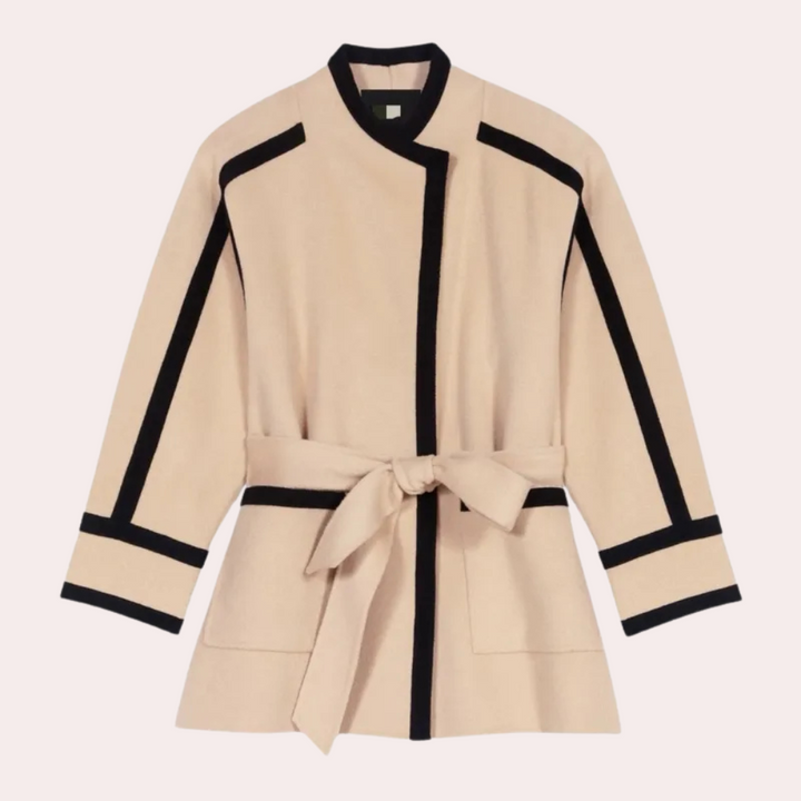 Beige damesjas met zwarte accenten en strikceintuur, minimalistisch design, lange mouwen, stijlvolle mode, herfst-winter collectie.