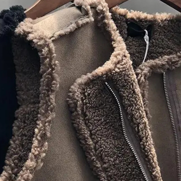 Bruine sherpa fleece jas met rits, hangend aan een houten hanger. Warme winterkleding, modieuze en comfortabele buitenkleding voor koude dagen.