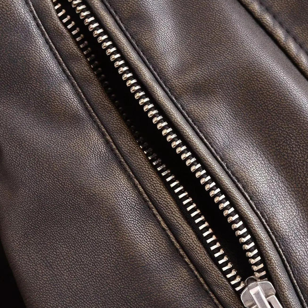 Bruine leren jas met metalen ritssluiting, close-up. Hoogwaardige textuur, modieuze kleding, herenkleding, leren jas, ritsdetails.