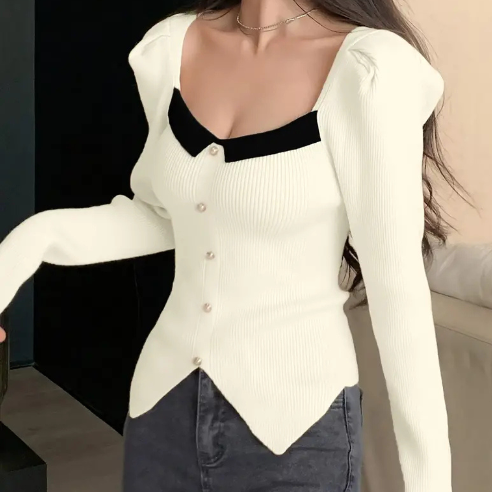 Vrouw draagt stijlvolle, crèmekleurige ribgebreide trui met knopen en zwarte kraag, perfect voor modieuze herfstoutfits.