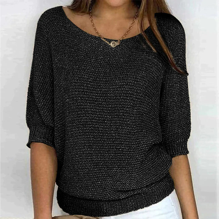 Zwarte gebreide damestrui met driekwart mouwen en ronde hals, gedragen door model. Perfect voor casual en stijlvolle outfits.