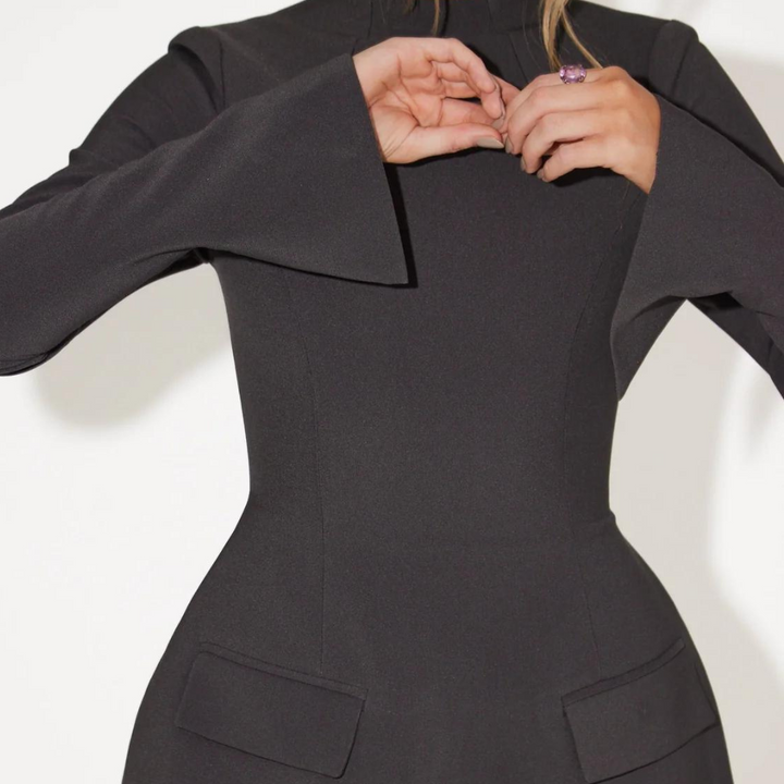 Vrouw in elegante zwarte jurk met wijde mouwen en paarse ring. Mode, stijlvolle kleding, minimalistisch design, moderne damesmode.