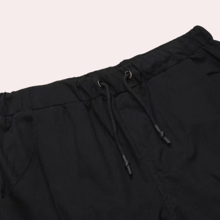 Zwarte joggingbroek met elastische tailleband en trekkoord, comfortabele pasvorm, ideaal voor casual en sportieve outfits.