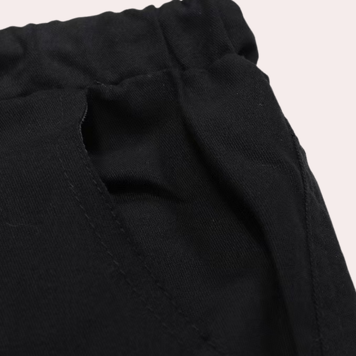 Zwarte katoenen broek met elastische tailleband en steekzakken, close-up. Comfortabele herenmode, casual stijl, hoogwaardige stof.