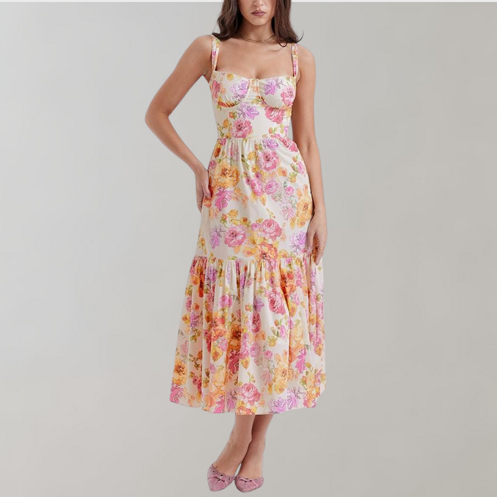 Vrouw in lange bloemenjurk met roze en gele bloemenprint, mouwloos ontwerp, elegante zomerjurk, modieuze dameskleding, casual chique stijl.