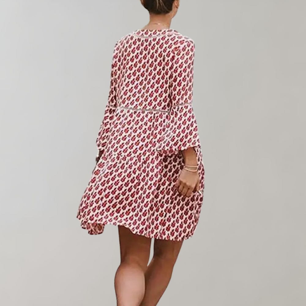 Vrouw in rode jurk met wit patroon, driekwart mouwen, draaiend. Modieuze dameskleding, casual stijl, zomerjurk.