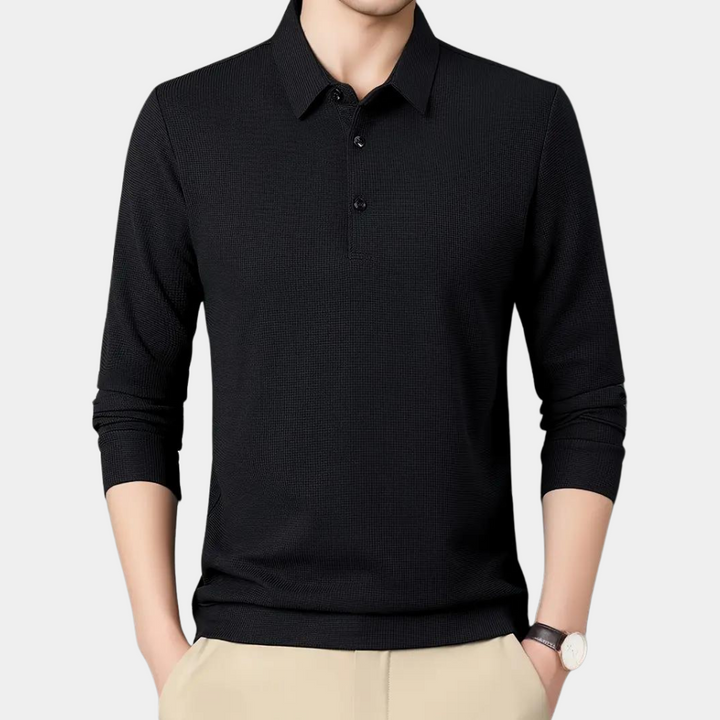 Zwarte herenpolo met lange mouwen, klassieke kraag en knoopsluiting, gedragen door een model. Perfect voor casual en zakelijke outfits.