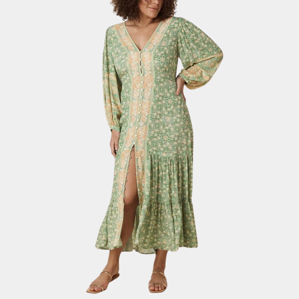 Vrouw in lange groene bloemenjurk met V-hals en knoopsluiting, boho-stijl, lange mouwen, zomermode, casual elegantie.
