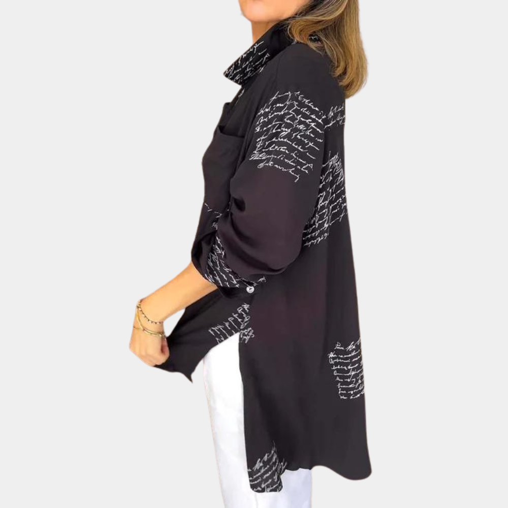 Zwarte blouse met witte tekstprint, lange mouwen en kraag, gedragen door model. Modieuze dameskleding, geschikt voor casual en zakelijke outfits.