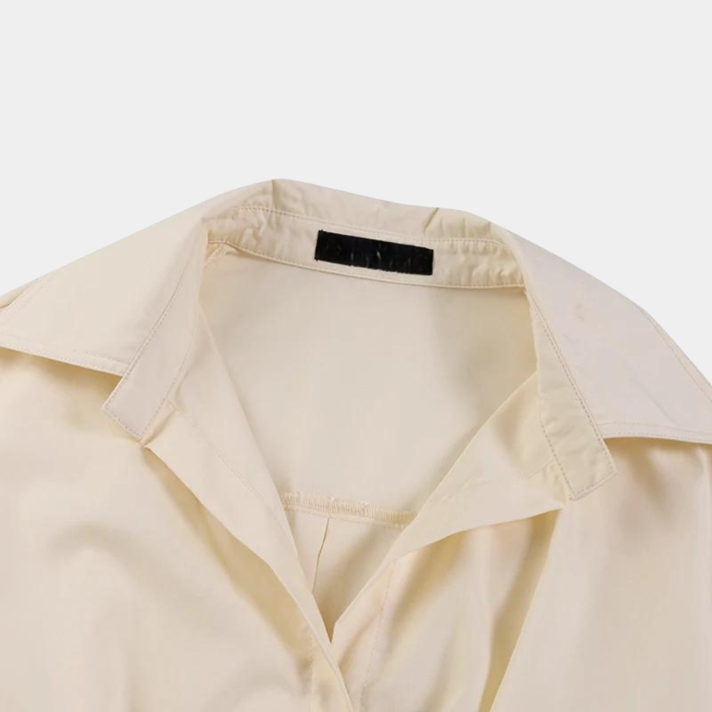 Beige damesblouse met kraag, elegante zakelijke kleding, close-up van de stof en kraagdetails, modieuze damesmode, hoogwaardige blouse.