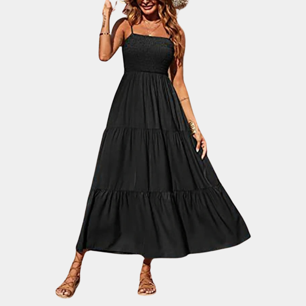 Zwarte maxi-jurk met spaghettibandjes, strapless ontwerp en gelaagde rok. Perfect voor zomerse gelegenheden en casual mode.