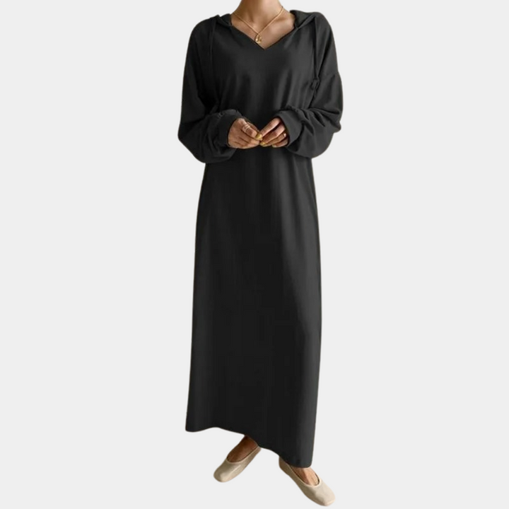 Zwarte lange jurk met V-hals en lange mouwen, gedragen door model. Elegante damesmode, comfortabele pasvorm, geschikt voor casual en formele gelegenheden.