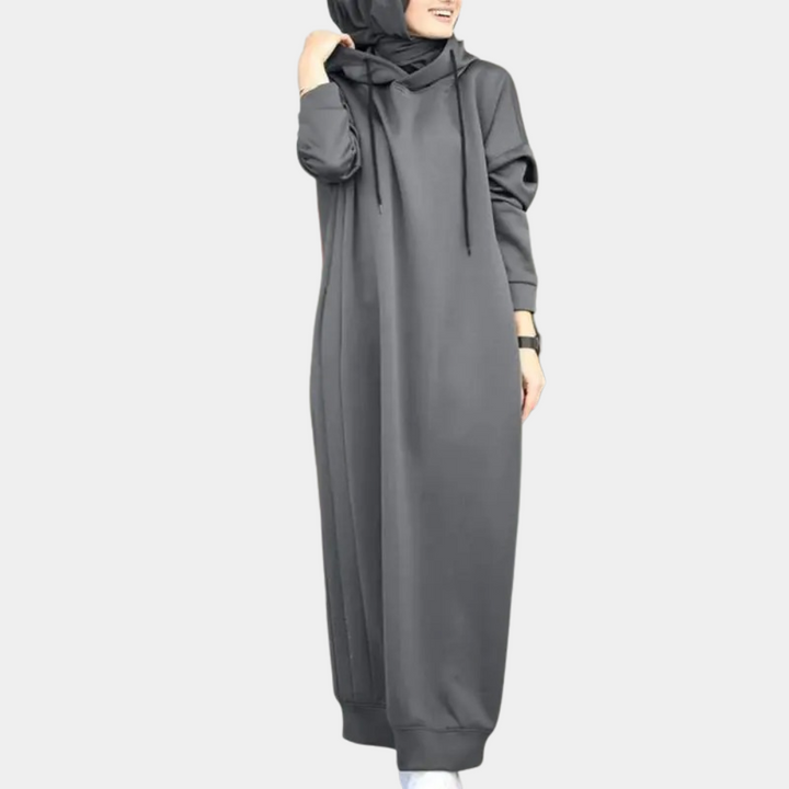 Grijze damesjurk met capuchon, lange mouwen en losse pasvorm. Modieuze en comfortabele kleding voor dagelijks gebruik.