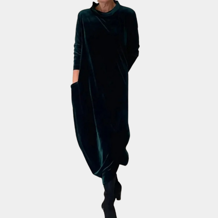 Donkergroene fluwelen maxi-jurk met lange mouwen en zakken, elegant en comfortabel, perfect voor herfst- en wintermode.