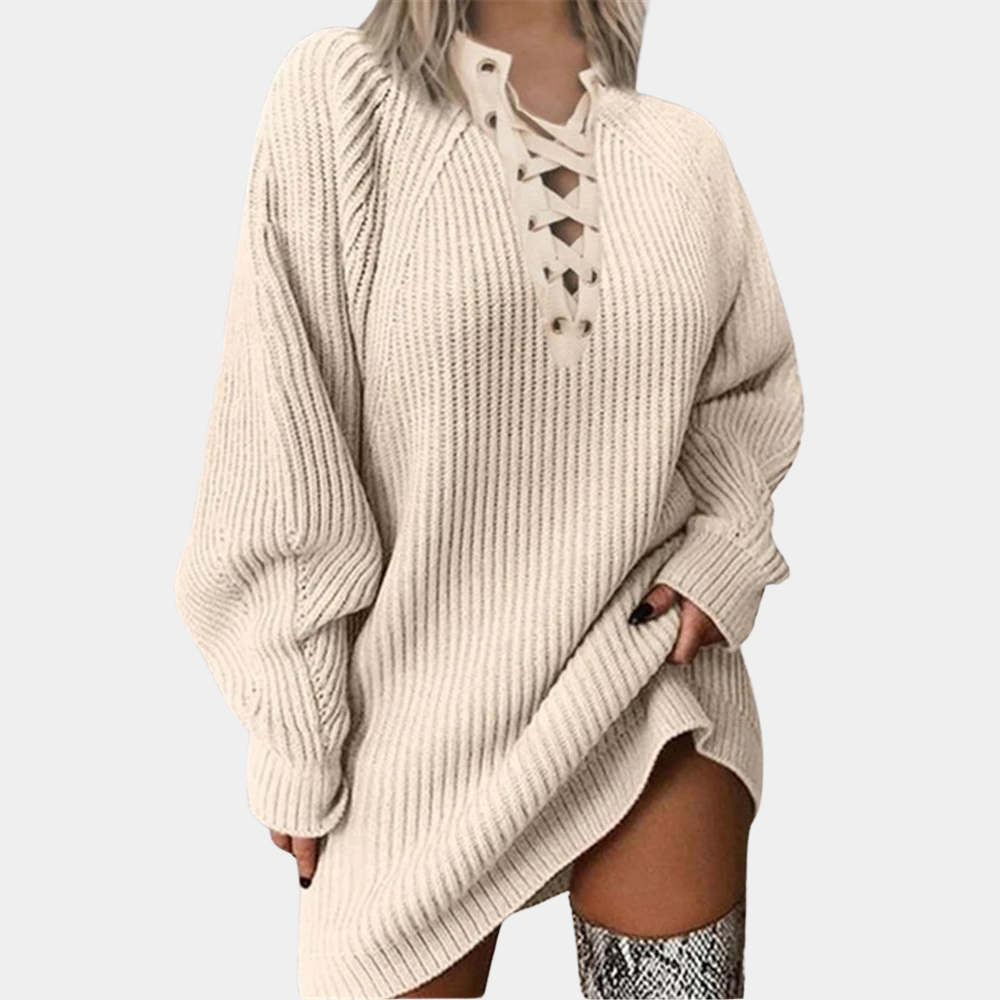 Beige oversized gebreide trui met veterhals en lange mouwen, gedragen door model. Trendy damesmode, comfortabele herfst- en winterkleding.