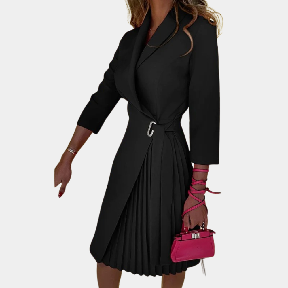 Elegante zwarte jurk met plissérok en driekwart mouwen, gecombineerd met een roze handtas. Perfect voor stijlvolle damesmode.