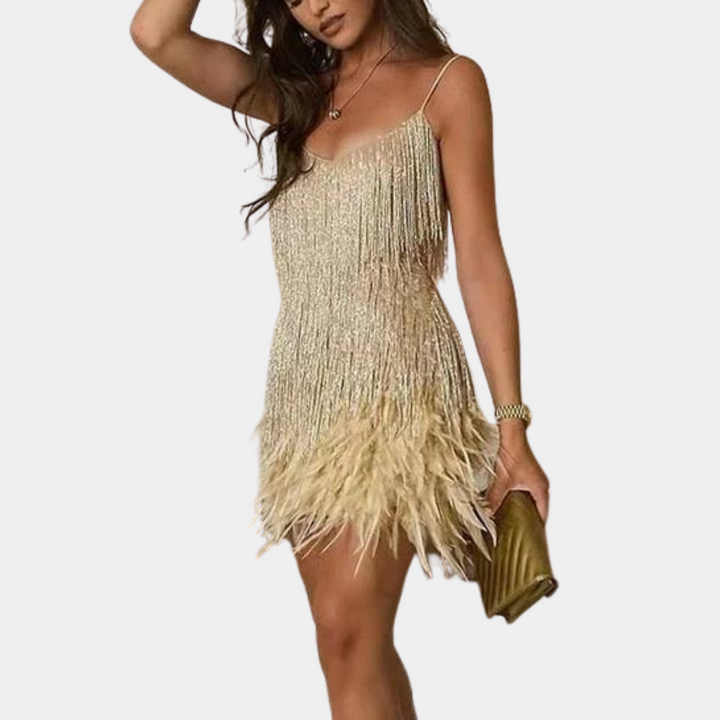 Gouden jurk met franjes en veren, gedragen door vrouw, met gouden clutch. Perfect voor feestelijke gelegenheden. Trendy mode, elegante stijl.