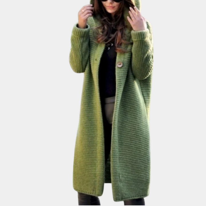 Vrouw in lange groene gebreide jas met capuchon, modieuze winterkleding, comfortabele damesjas, trendy en stijlvol voor koud weer.