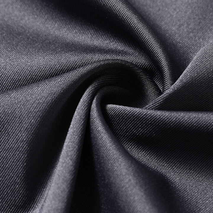Donkergrijze, glanzende stof in close-up, met een gedraaide textuur. Ideaal voor mode, interieur en luxe textieltoepassingen.