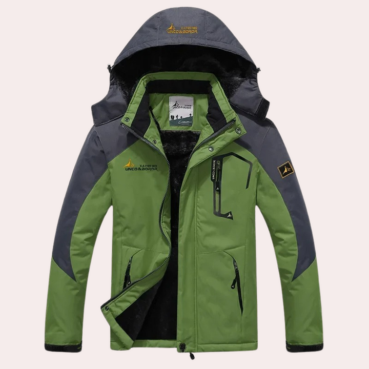 Groene outdoor jas met capuchon, waterdicht en winddicht, geschikt voor wandelen en kamperen. Voorzien van meerdere zakken en verstelbare manchetten.