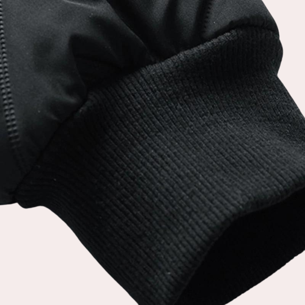 Zwarte jas met elastische geribbelde manchetten, detailopname. Hoogwaardige winterkleding, duurzame stof, stijlvol ontwerp.