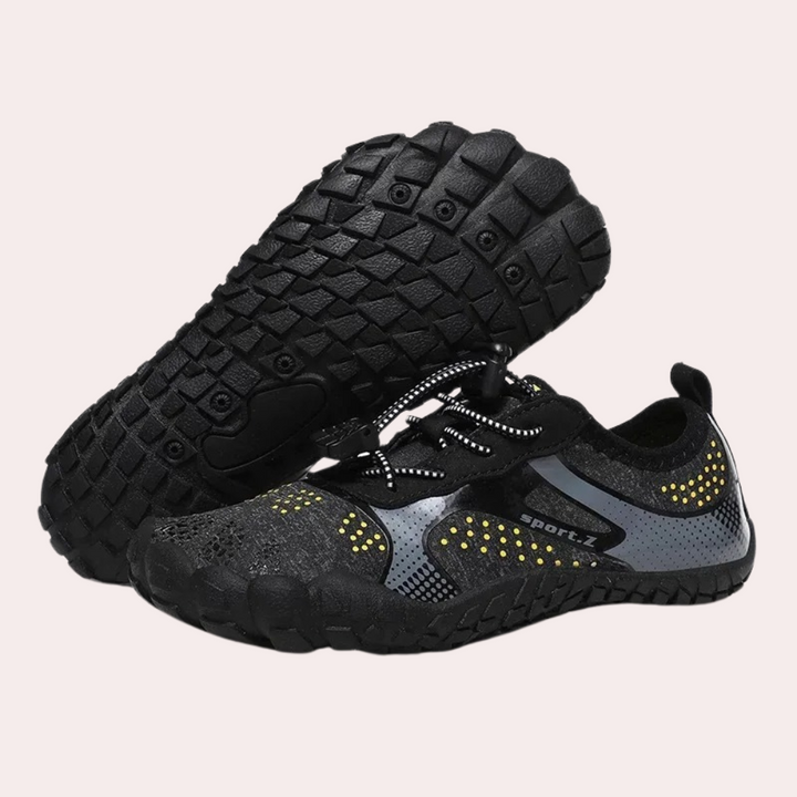 Zwarte minimalistische sportschoenen met gele accenten, antislipzool en ademend mesh. Ideaal voor hardlopen en outdoor activiteiten.