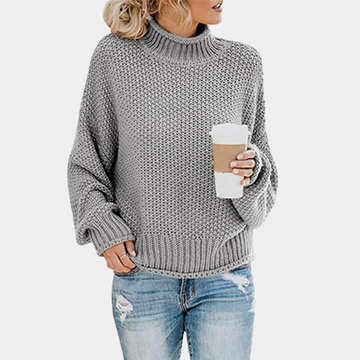 Vrouw in grijze gebreide trui met koffiebeker, casual mode, herfstkleding, comfortabele oversized trui, trendy damesoutfit, jeans.