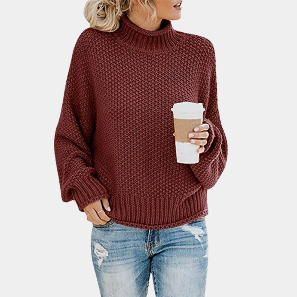 Vrouw in wijnrode gebreide trui met col, houdt een koffiebeker vast. Casual outfit met blauwe spijkerbroek. Herfstmode, comfortabele kledingstijl.