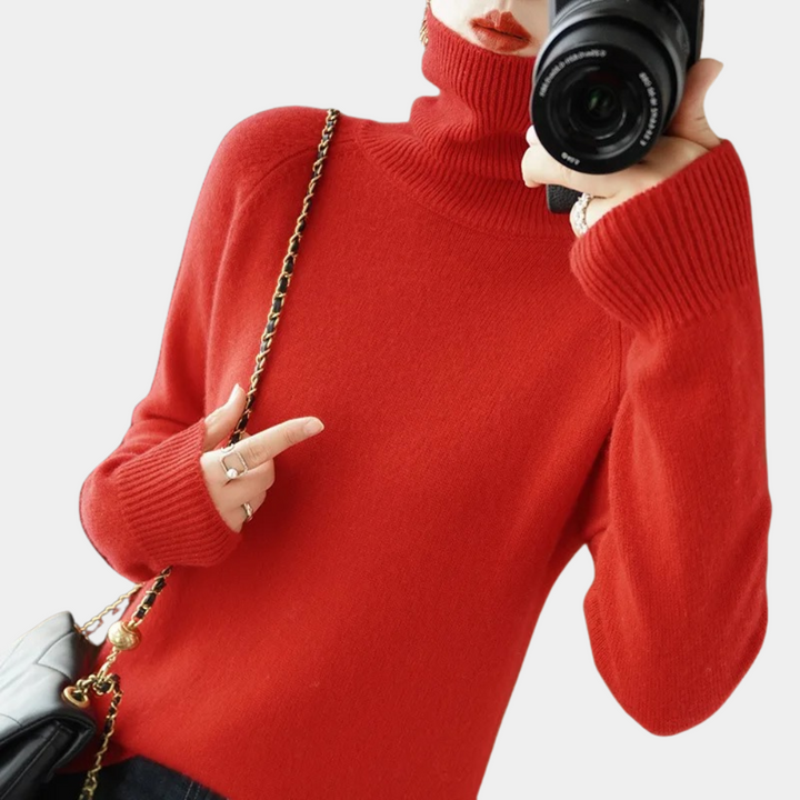 Vrouw in rode coltrui met camera en zwarte schoudertas. Modieuze winterkleding, warme trui, damesmode, casual stijl, herfstoutfit.