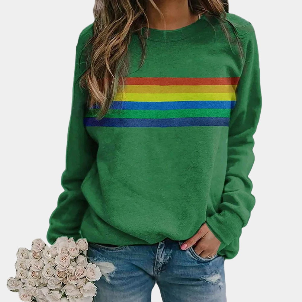 Vrouw in groene trui met regenboogstrepen, casual outfit, blauwe jeans, houdt een boeket witte rozen vast. Trendy damesmode, kleurrijke sweater.