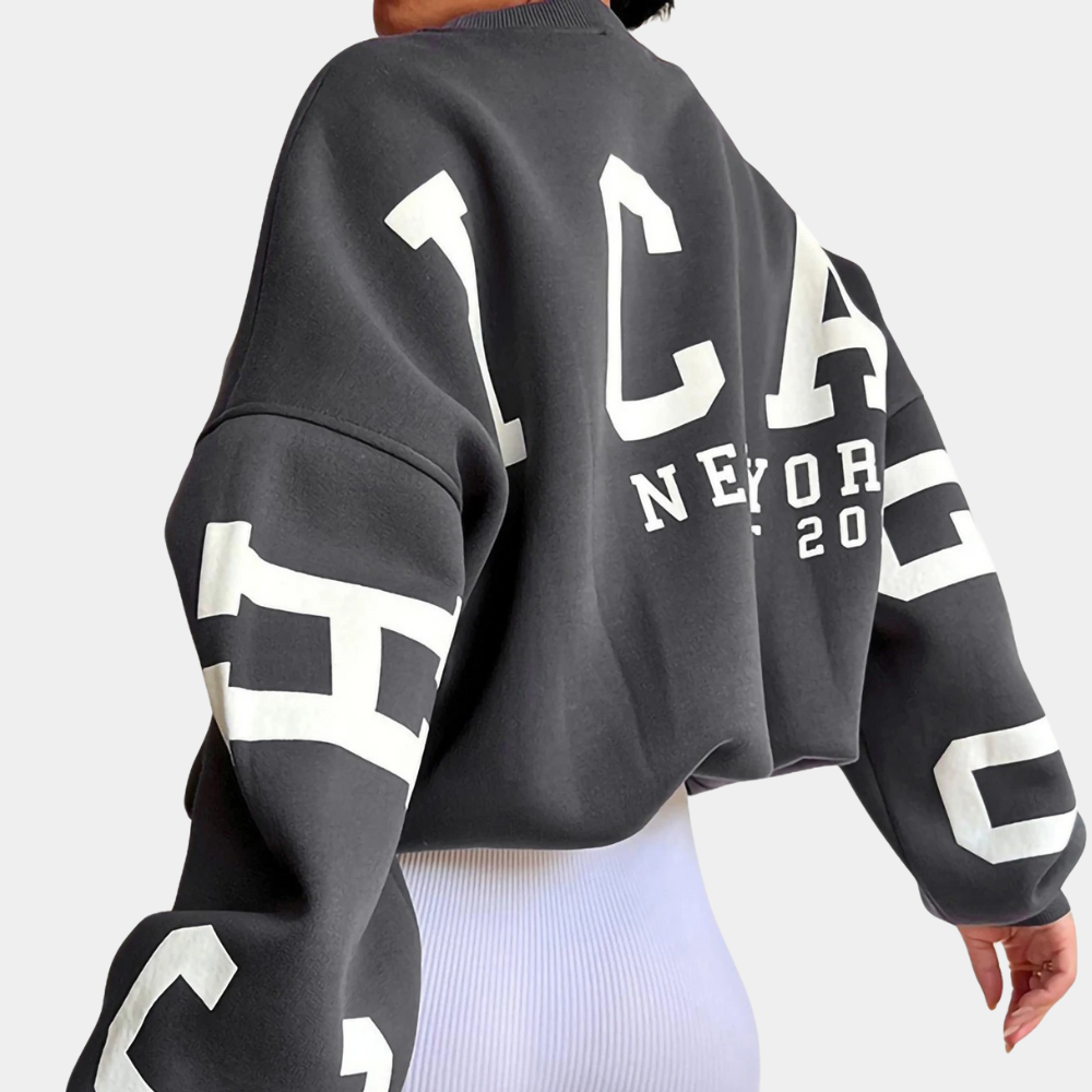 Grijze oversized sweatshirt met "Chicago New York 2020" opdruk, gedragen door model. Trendy streetwear, comfortabele pasvorm, casual mode.