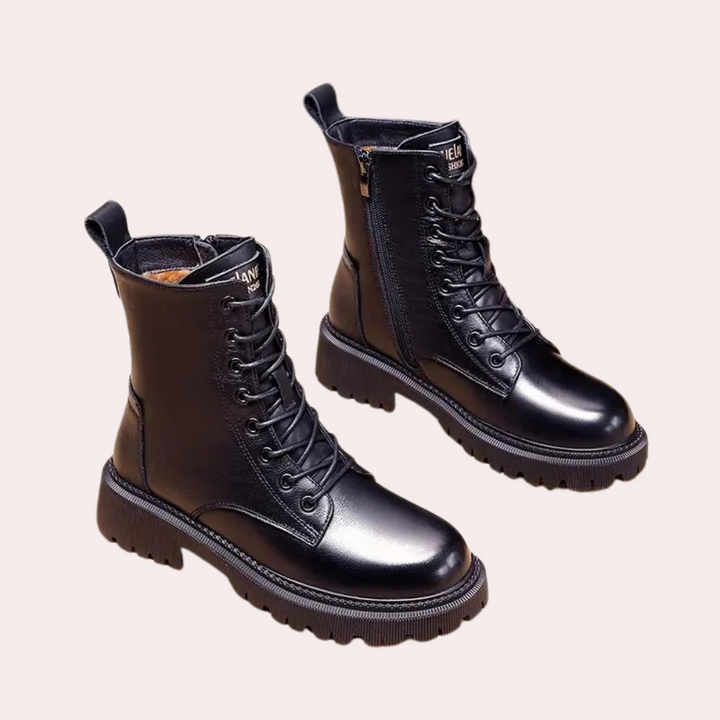 Zwarte leren veterlaarzen met dikke zool, zijrits en ronde neus. Modieuze damesboots, perfect voor herfst en winter. Comfortabel en stijlvol.