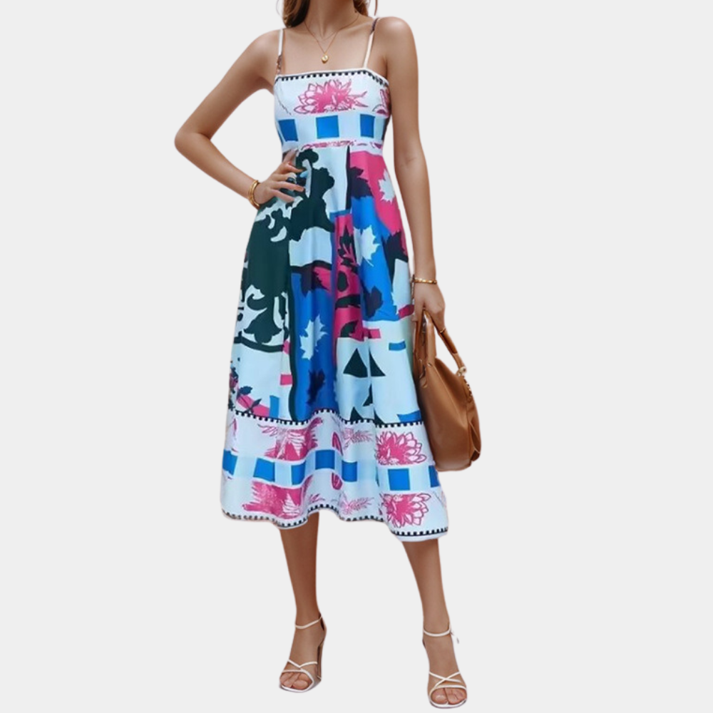 Vrouw in kleurrijke zomerjurk met abstract patroon, donkerblauw en roze tinten, draagt bruine handtas. Perfecte outfit voor zomerse dagen.