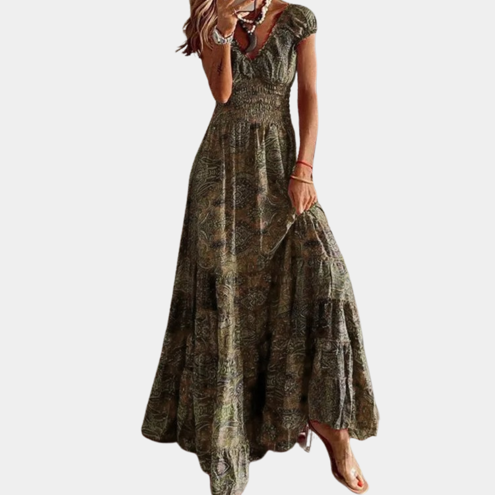 Vrouw in lange, bohemian jurk met paisleyprint, korte mouwen en V-hals. Perfect voor zomer, casual en elegante gelegenheden.