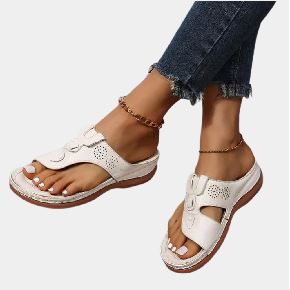 Beige leren sandalen met open teen en verstelbare riemen, gedragen door een persoon met jeans. Comfortabele zomerschoenen voor dames.