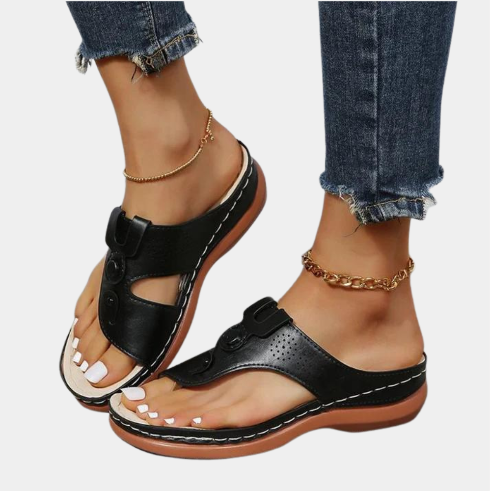 Zwarte leren dames sandalen met open teen en verstelbare bandjes, gedragen met enkelbandjes en jeans. Comfortabele zomerschoenen voor dagelijks gebruik.